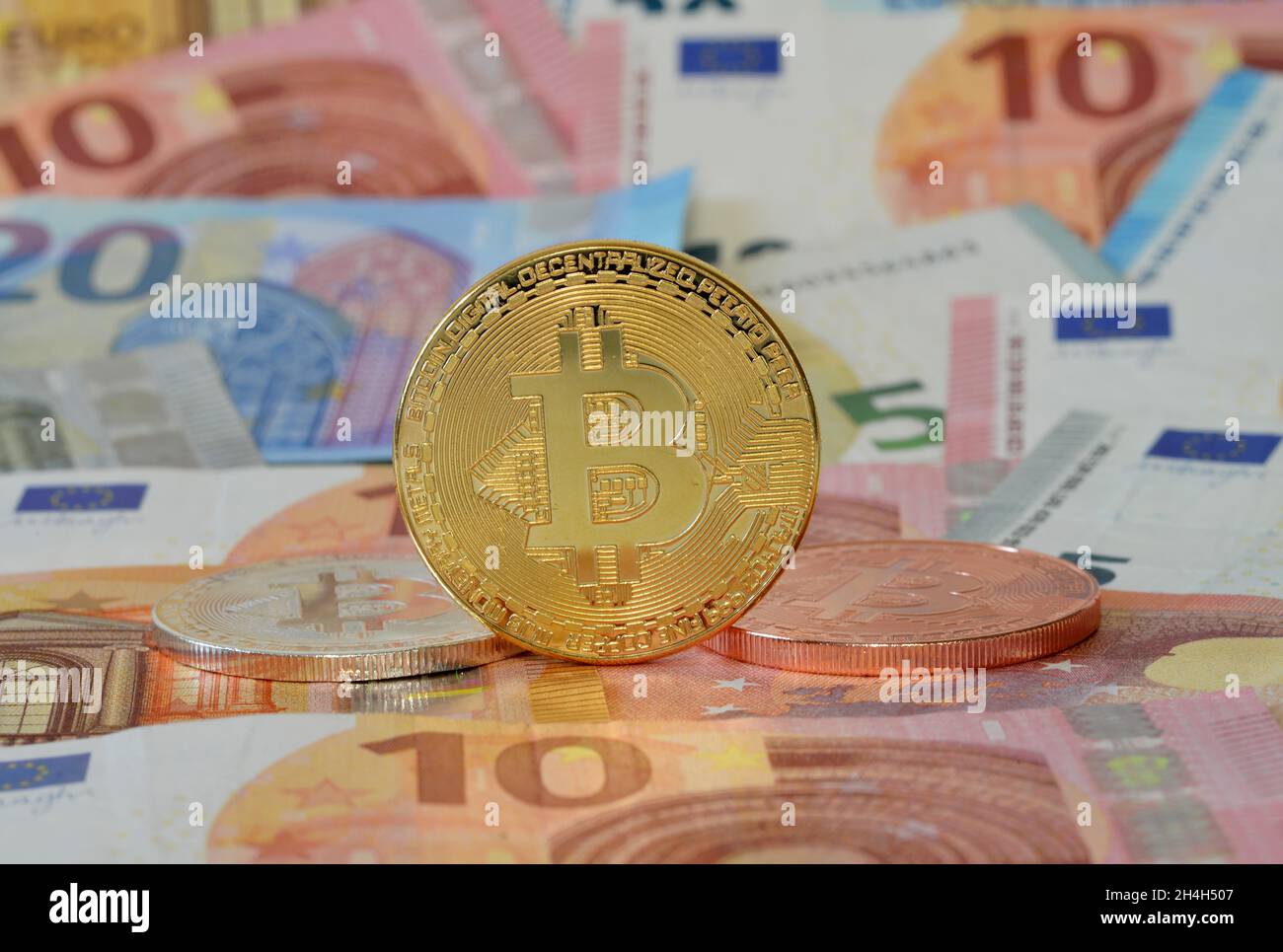 Monete in Bitcoin, banconote in euro Foto Stock