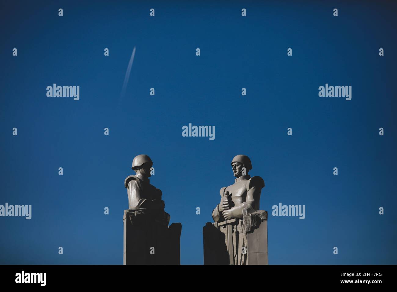 Bucarest, Romania - 27 ottobre 2021: Statua in stile comunista/sovietico raffigurante soldati con cielo chiaro sullo sfondo al Monumento al Sconosciuto He Foto Stock