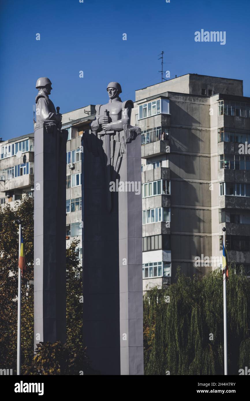 Bucarest, Romania - 27 ottobre 2021: Statua in stile comunista/sovietico raffigurante soldati con blocchi di appartamenti sullo sfondo. Foto Stock