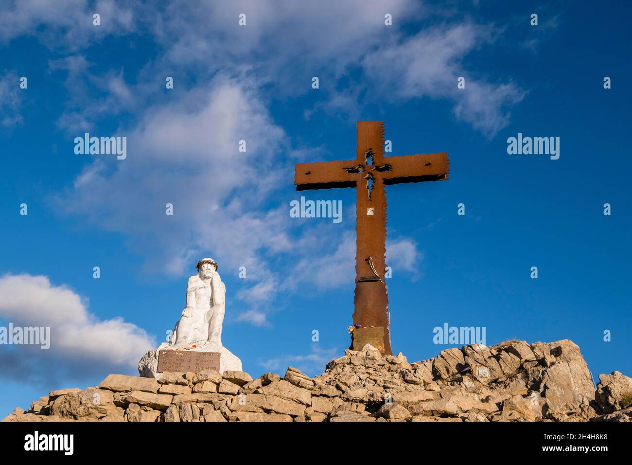 Croce di vetta e figura di Gesù sul Monte Castellaz, Parco Naturale Paneveggio pale di San Martino, Passo di Rollepass, Trentino, Italia Foto Stock