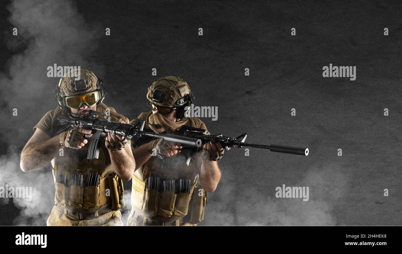 Durante un'operazione speciale, i soldati delle forze speciali professionali sono avvolti in fumo sullo sfondo di un muro di cemento scuro - sono Foto Stock