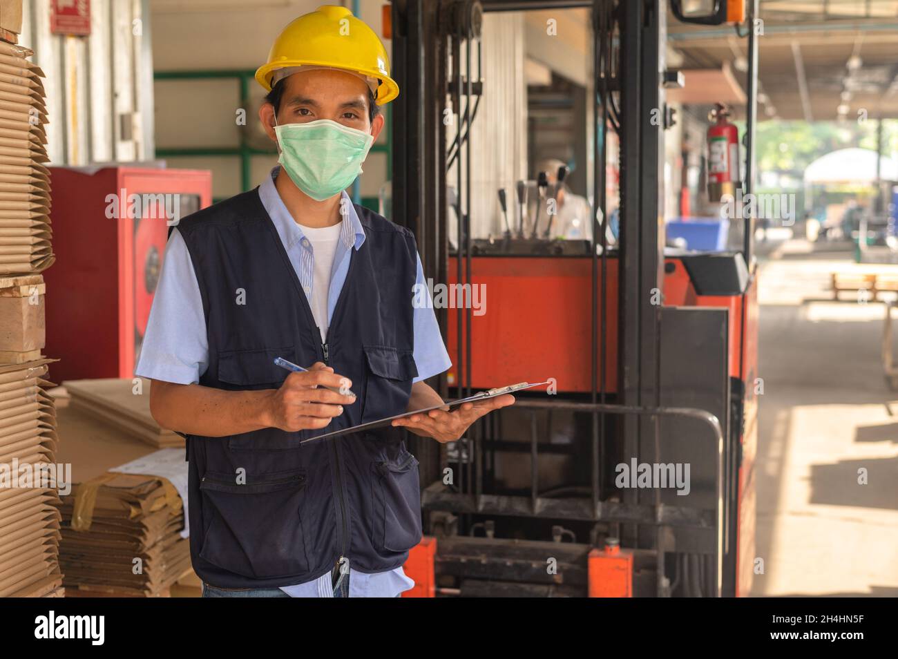 Lavoratore che controlla l'inventario delle materie prime in fabbrica Foto Stock
