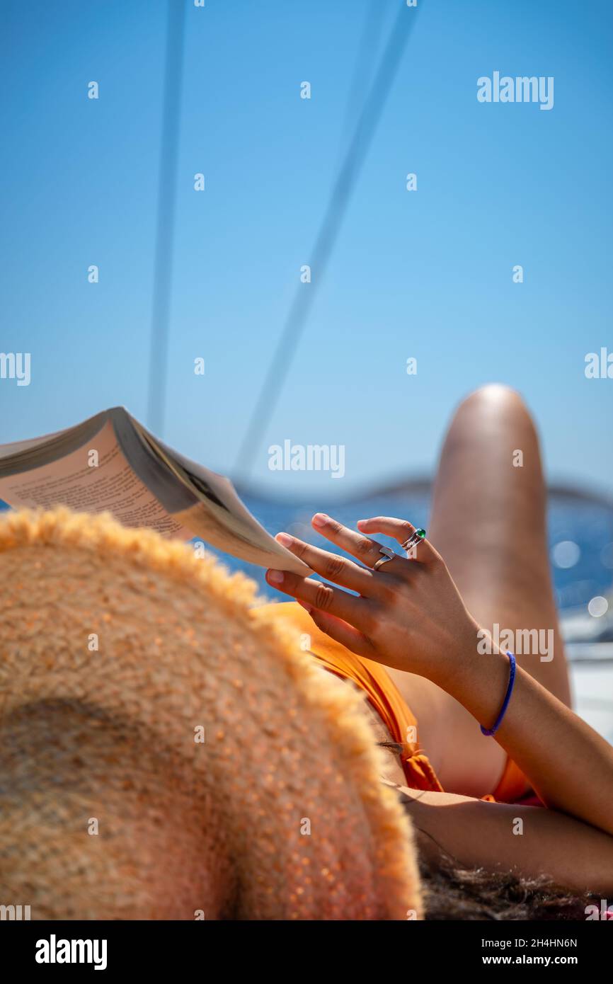 Traveler Girl con libro di lettura e abbronzatura di piacere sulla barca a vela. Vacanze estive attive. Viaggio in Grecia. Foto Stock