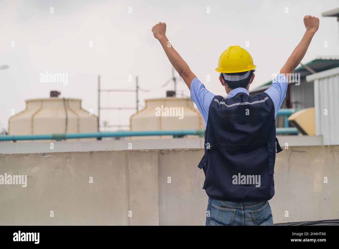 Ingegnere in piedi sul tetto dell'edificio di produzione dimostrare impegno e successo Foto Stock