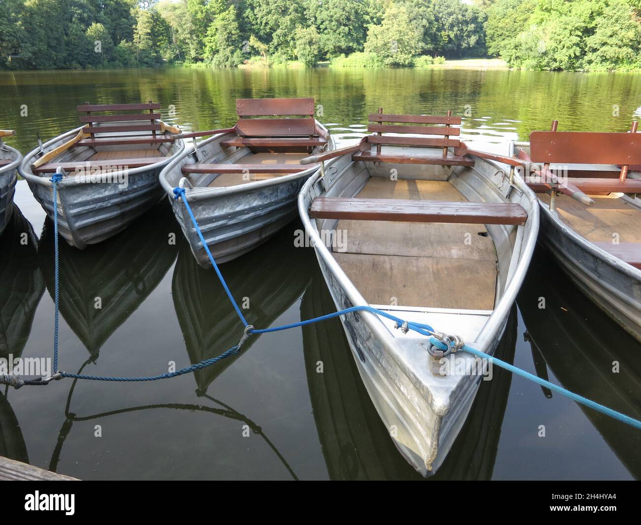 Barche a remi in alluminio sono ormeggiate nel lago e ormeggiate al molo Foto Stock