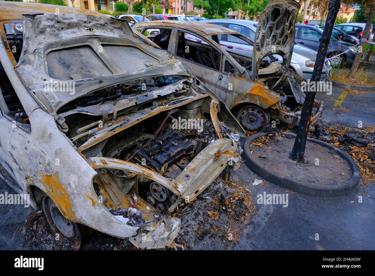 Auto bruciate nel parcheggio in strada. Sommossa, protesta civile, hooliganismo in città. Esplosione, incendio. Auto Foto Stock