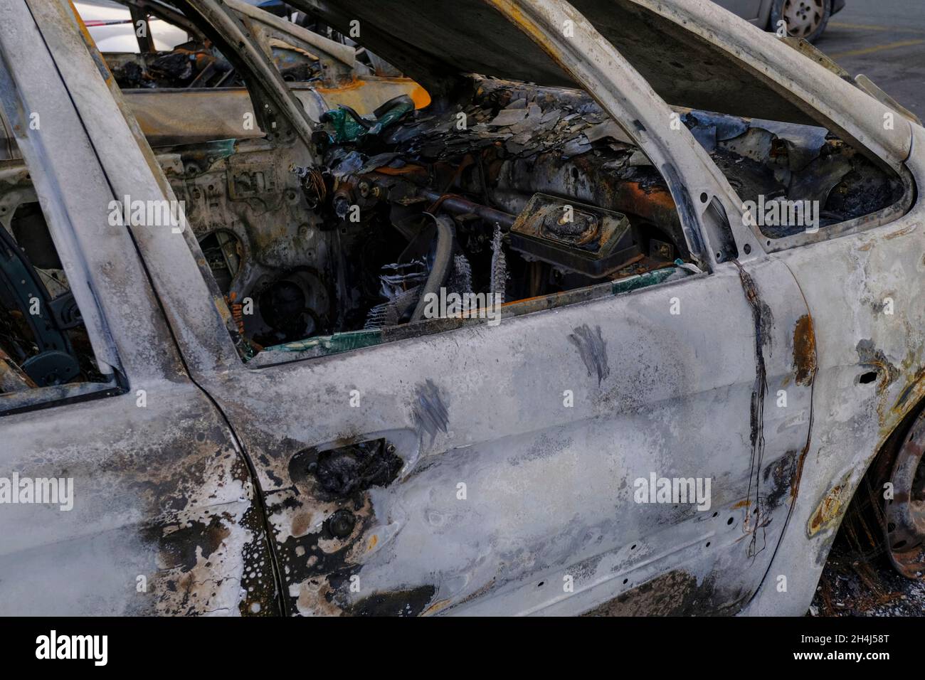 Porta dell'auto bruciata in primo piano. Sommossa, protesta civile, hooliganismo, criminale in città. Scad Foto Stock