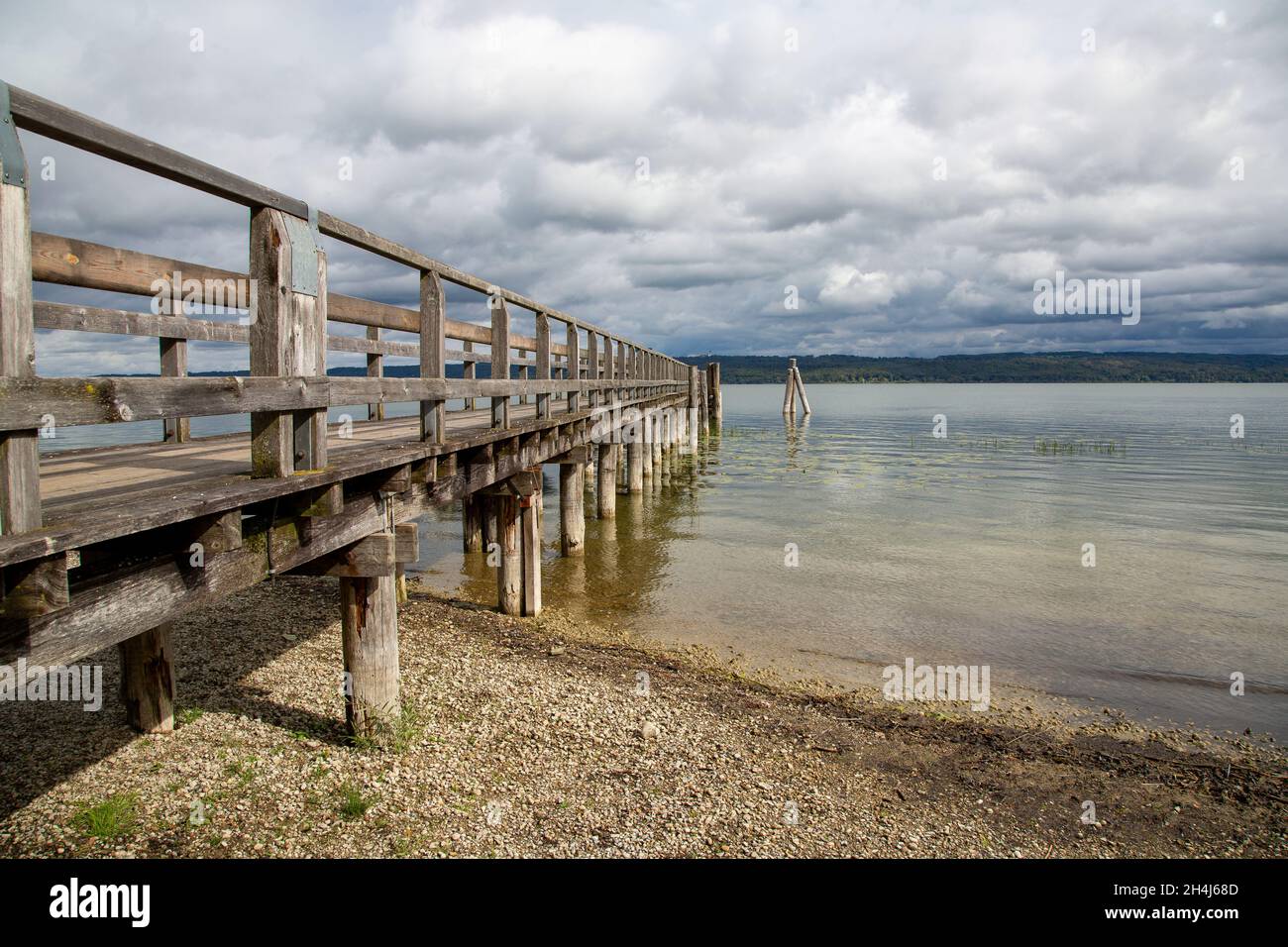 Pianerottolo in legno che si estende fino ad un grande lago in Baviera Foto Stock