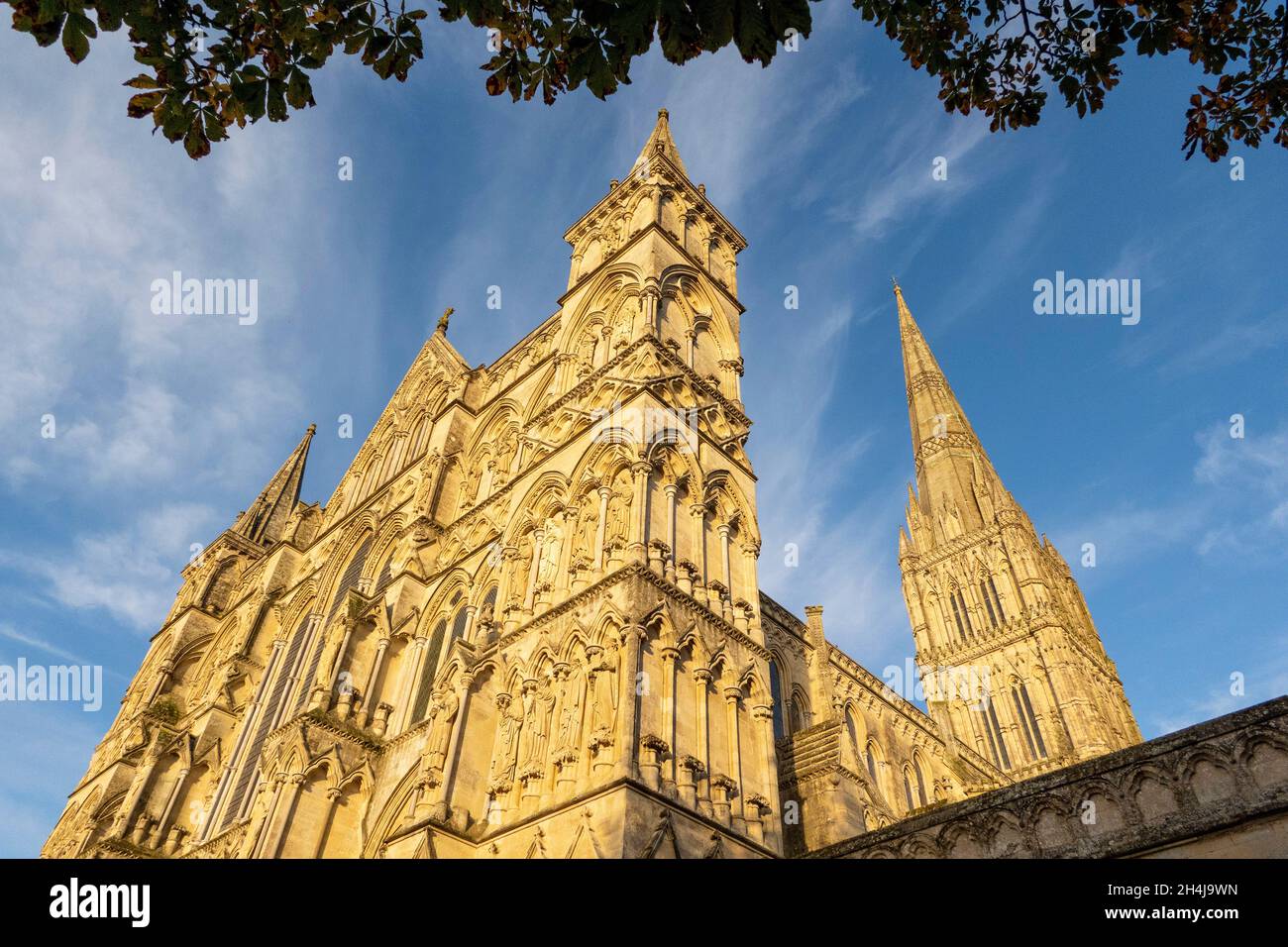 Salisbury, Wiltshire, Inghilterra, Regno Unito. 2021. Cattedrale di Salisbury vista con un bagliore della luce della sera e cielo blu. La guglia è alta 404 piedi e talles Foto Stock