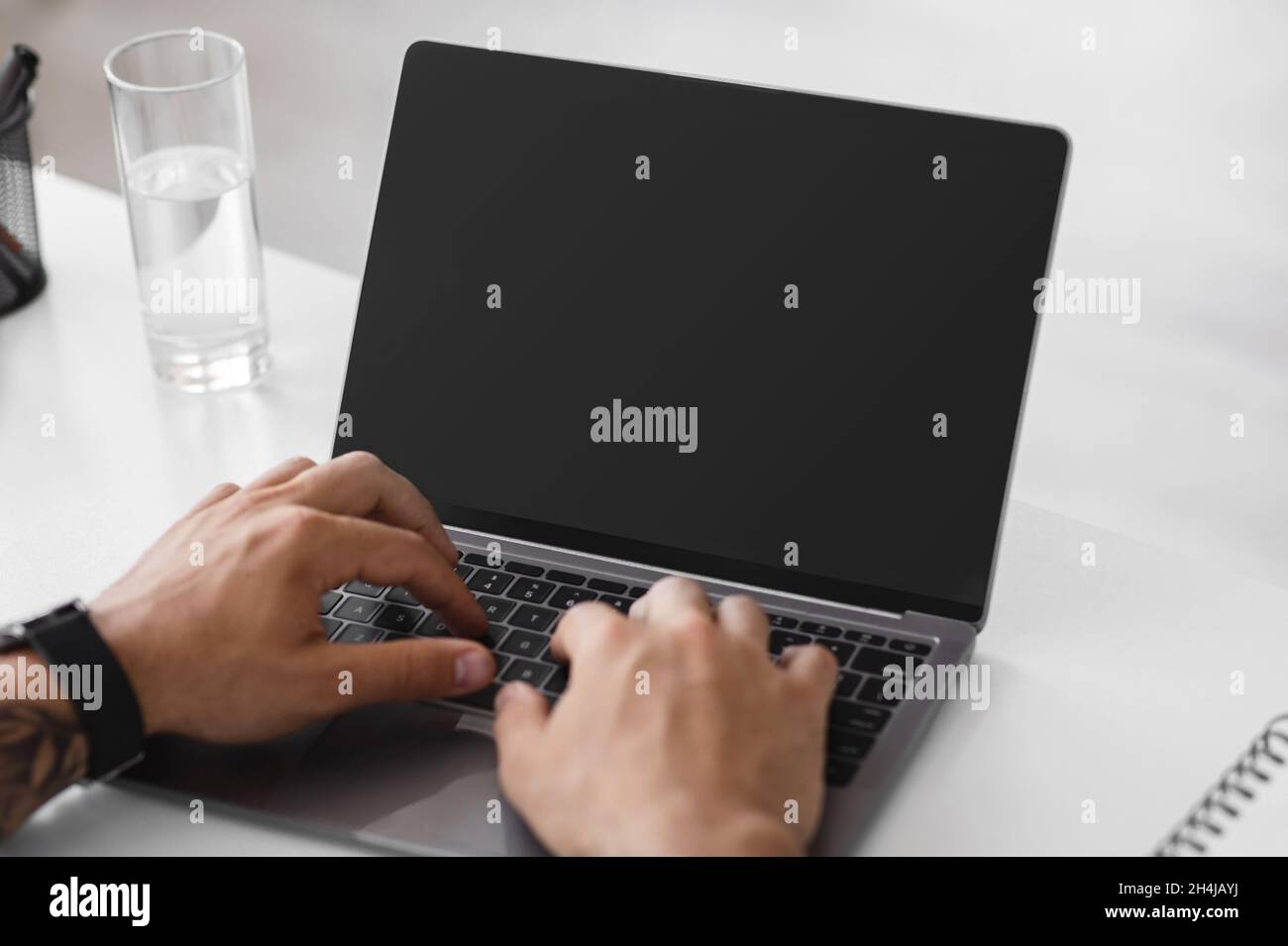 Un uomo d'affari europeo maturo e irriconoscibile che lavora su un notebook con schermo vuoto Foto Stock
