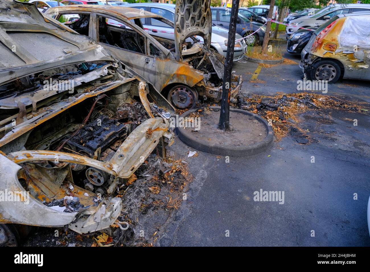 Auto bruciate nel parcheggio in strada. Sommossa, protesta civile, hooliganismo in città. Esplosione, incendio. Auto Foto Stock