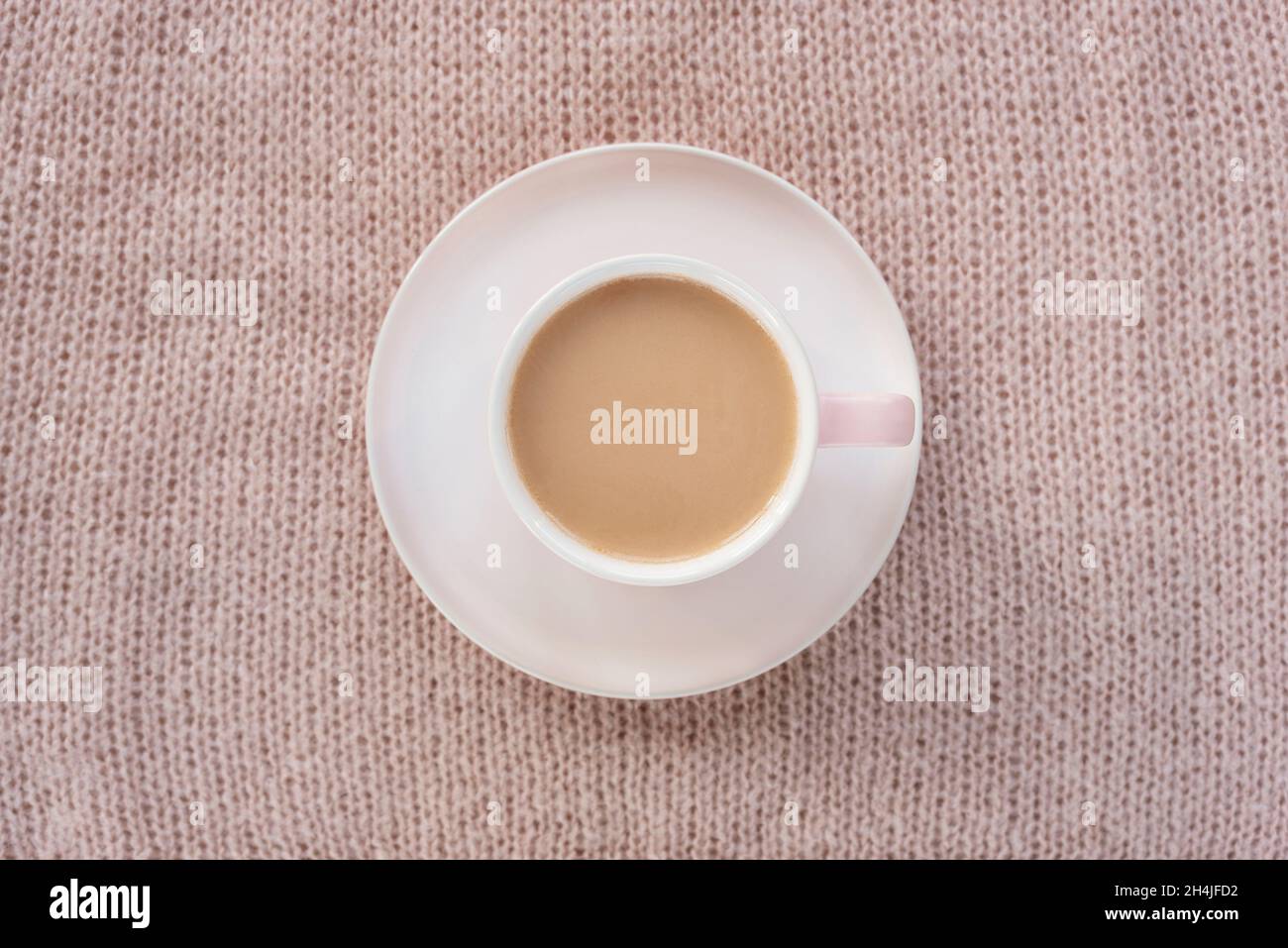 Tazza di caffè su fondo caldo lavorato a maglia plaid. Concetto invernale. Vista dall'alto, piatto. Foto Stock