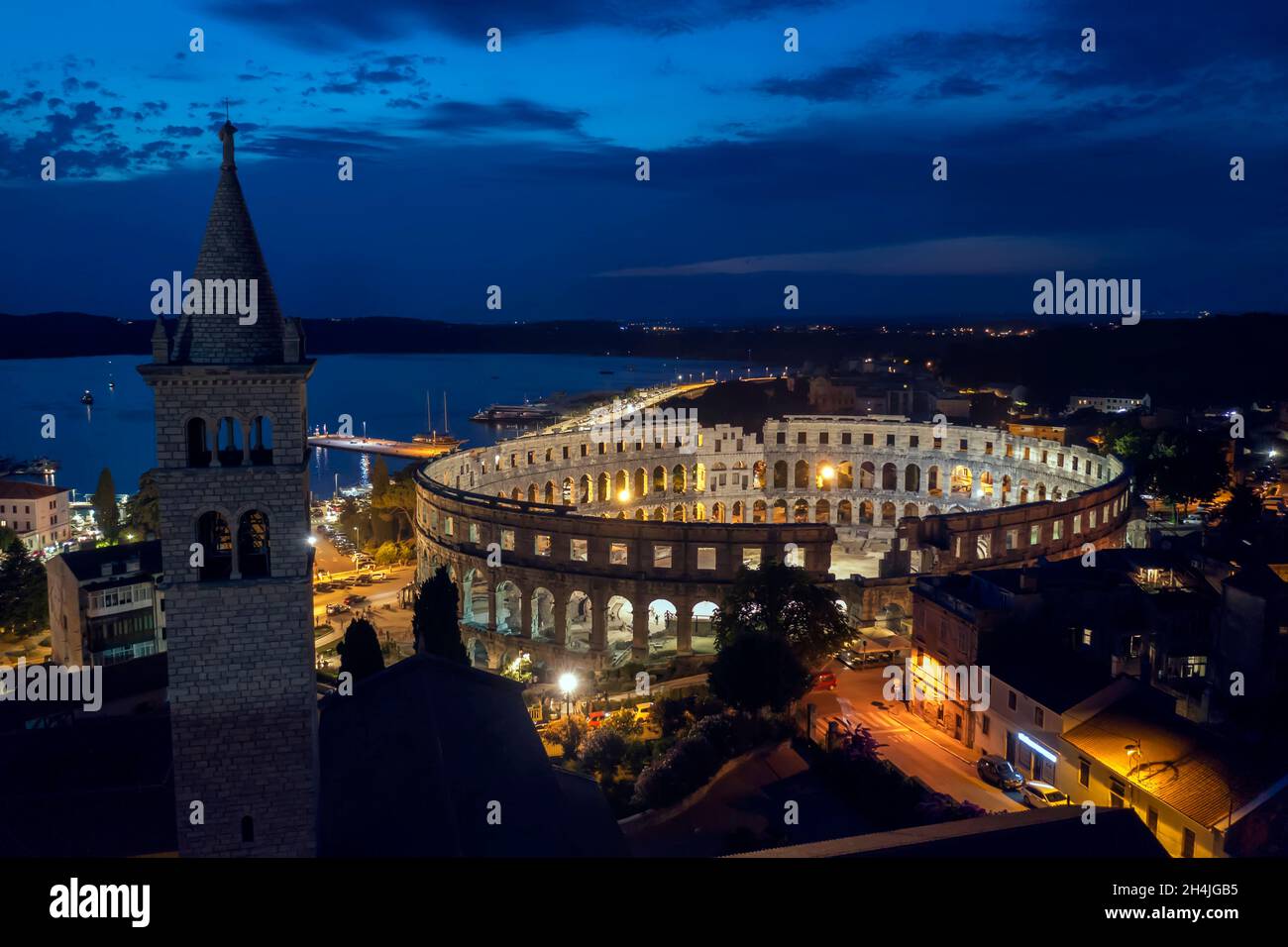 Una vista aerea dell'afitheater di Pola di notte, sul campanile sinistro della chiesa di Sant'Antun, Istria, Croazia Foto Stock