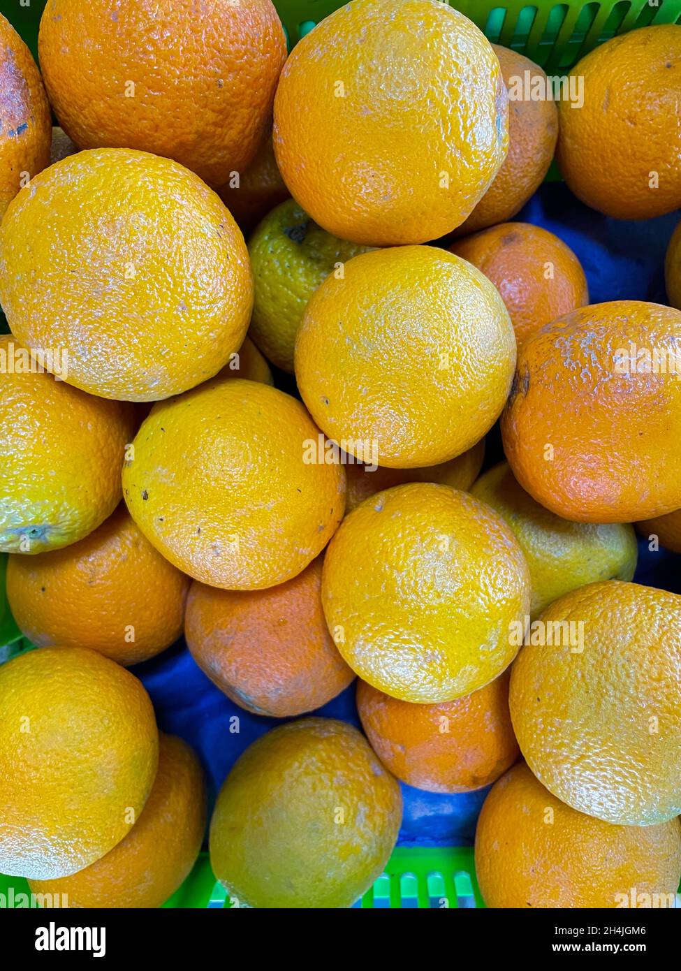 Arance fresche e succose tenute insieme su una mensola di un deposito di verdure Foto Stock
