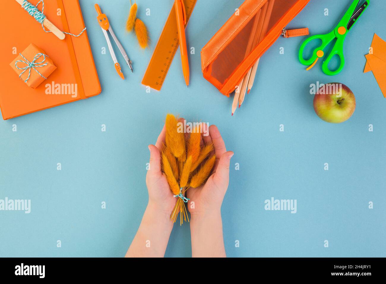 torna a scuola concetto bambino mano tiene bouquet di fiori d'arancio insegnanti giorno Foto Stock