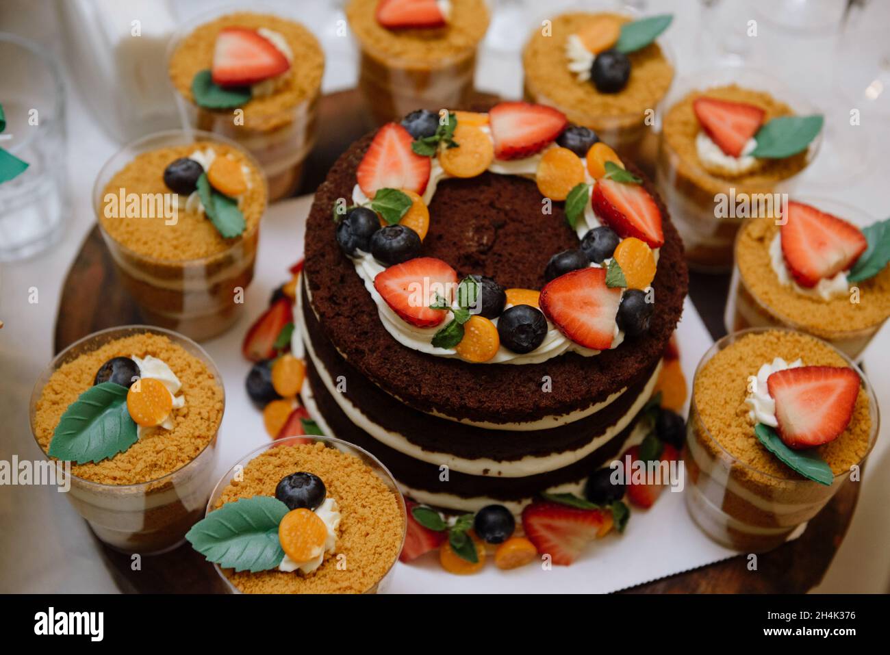 Pan di Spagna al cioccolato con panna e frutta fresca e dessert a briciole individuali Foto Stock