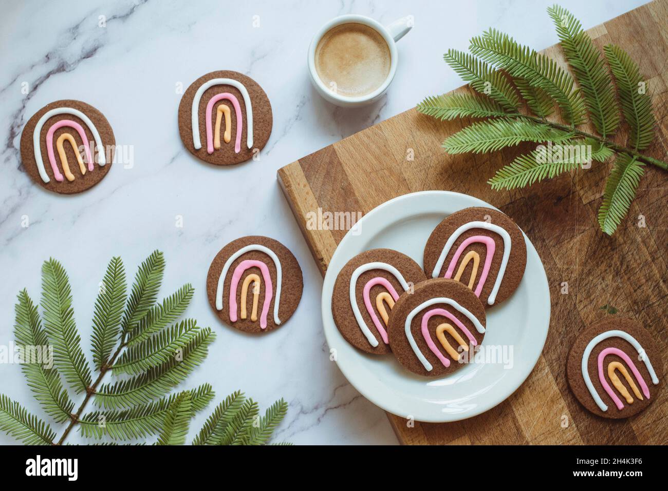 Vista dall'alto di una tazza di caffè e biscotti arcobaleno sul tavolo Foto Stock