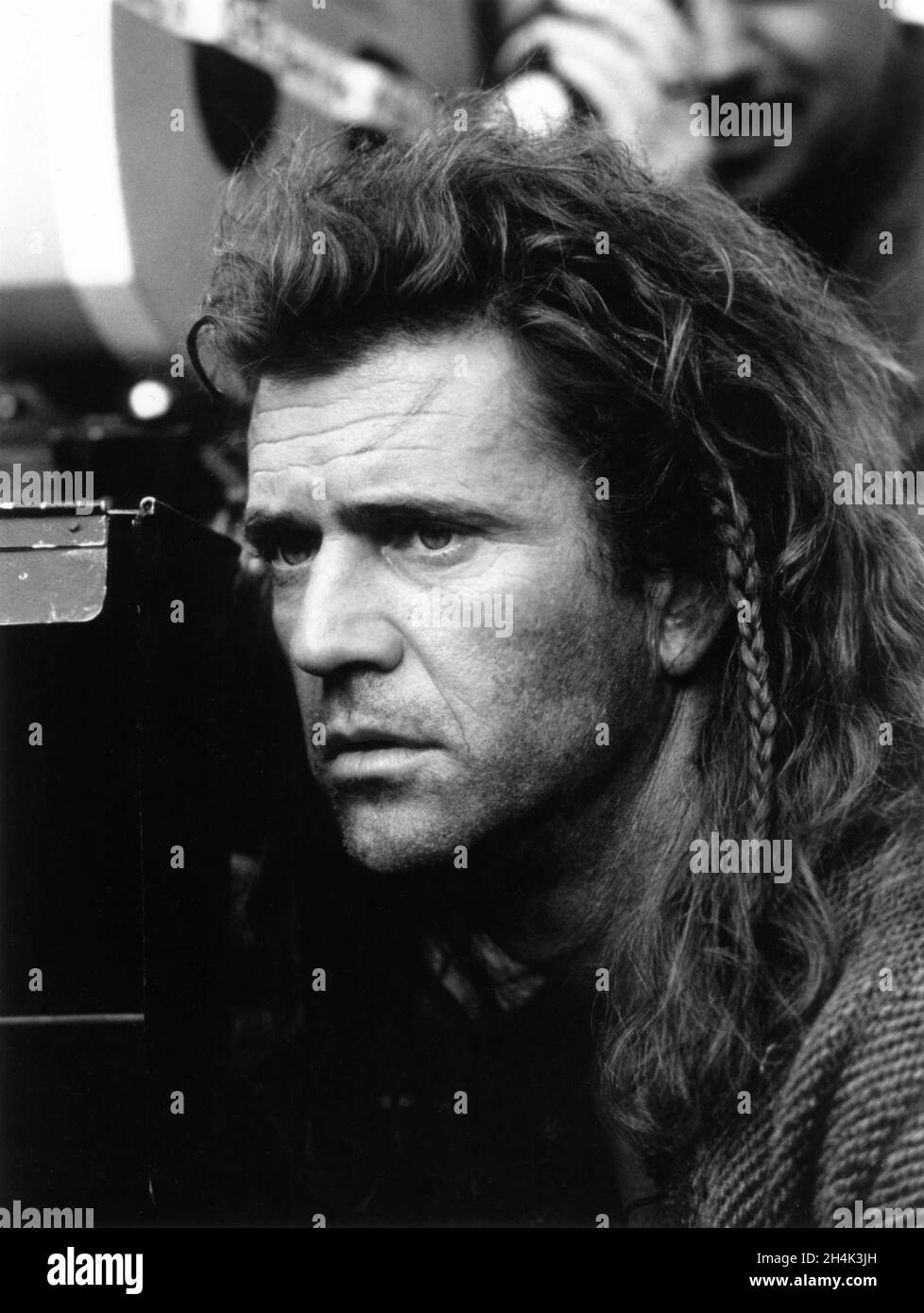 Regista / Produttore / Star MEL GIBSON by Movie Camera in costume come William Wallace sul set location candid durante le riprese di BRAVEHEART 1995 scrittore Randall Wallace musica James Horner icona produzioni / The Ladd Company / B.H. Finanza C.V. / 20th Century Fox (World) - Paramount Pictures (US) Foto Stock