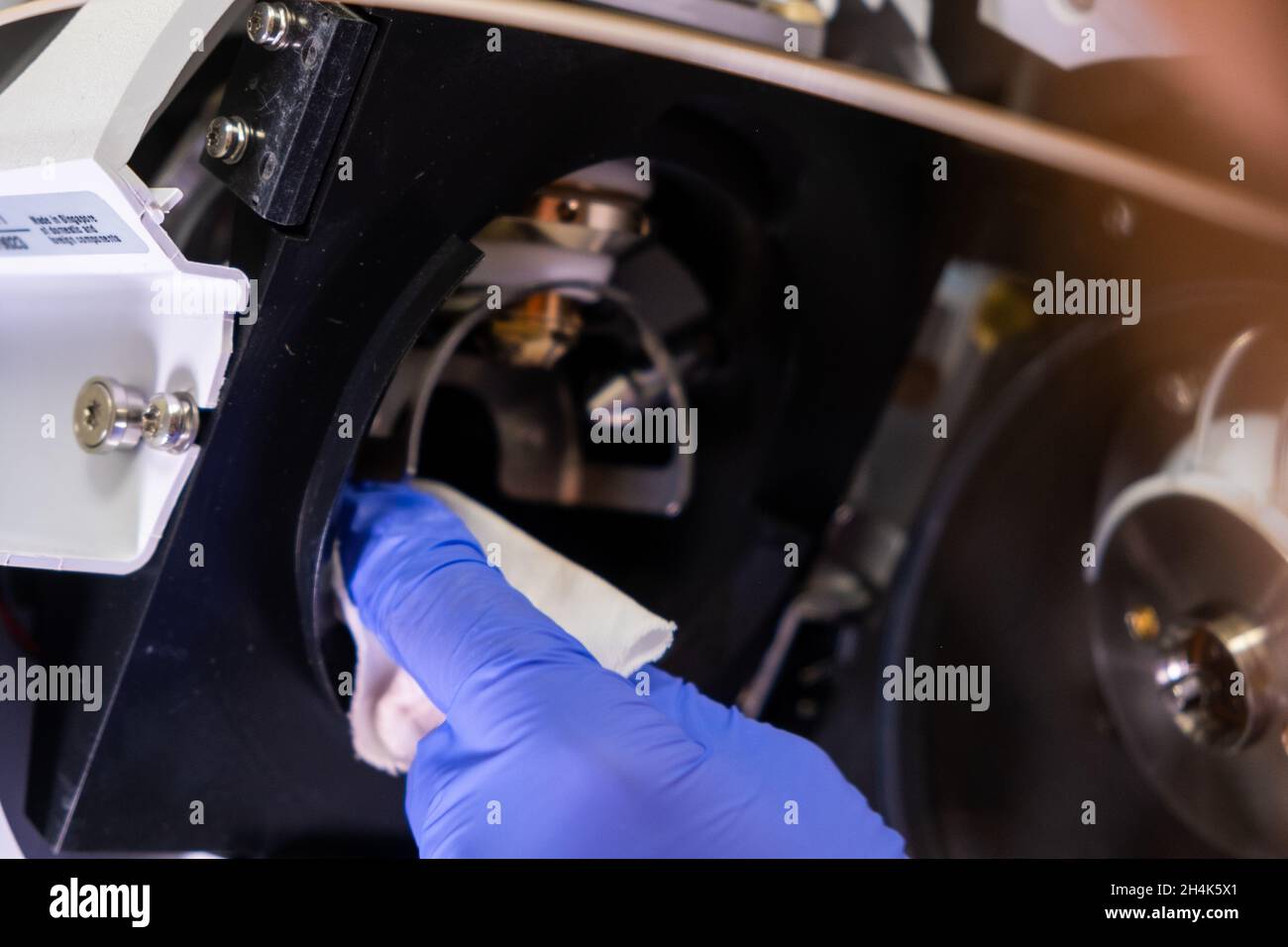 Pulizia della fonte di ioni dello spettrometro di massa da parte di un operatore di laboratorio con guanti di gomma. LC MS, cromatografia liquida e routine quotidiana Foto Stock