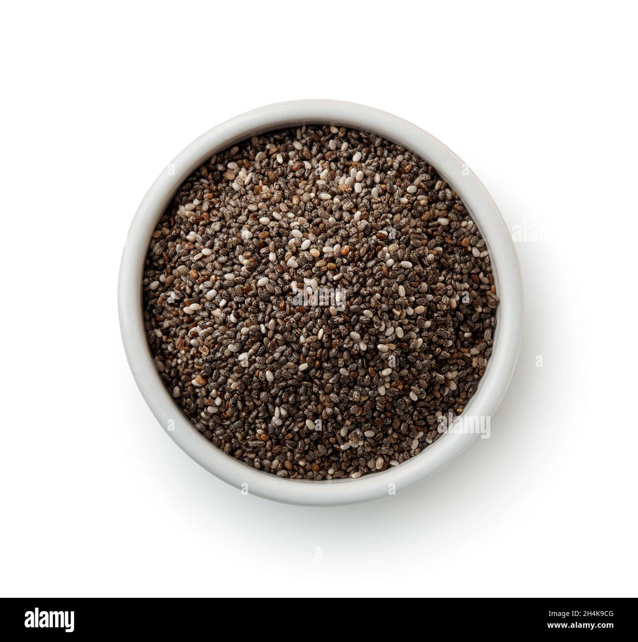 Vista dall'alto dei semi di chia in ciotola di ceramica isolata su bianco Foto Stock