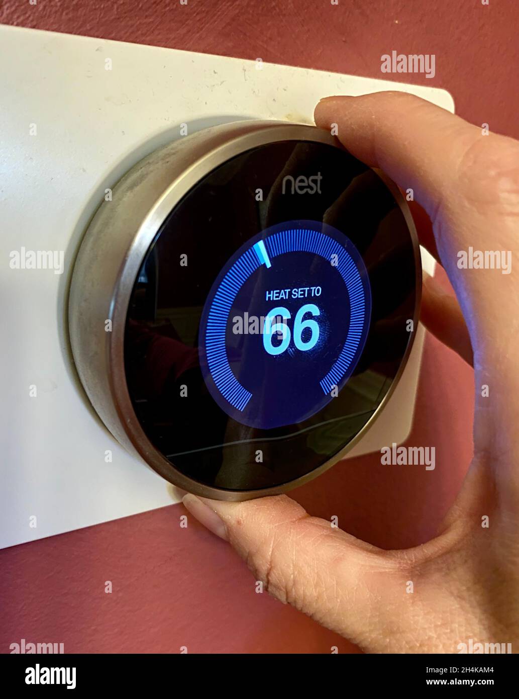 Impostazione della temperatura su un termostato Nest con il calore acceso all'inizio dell'inverno Foto Stock