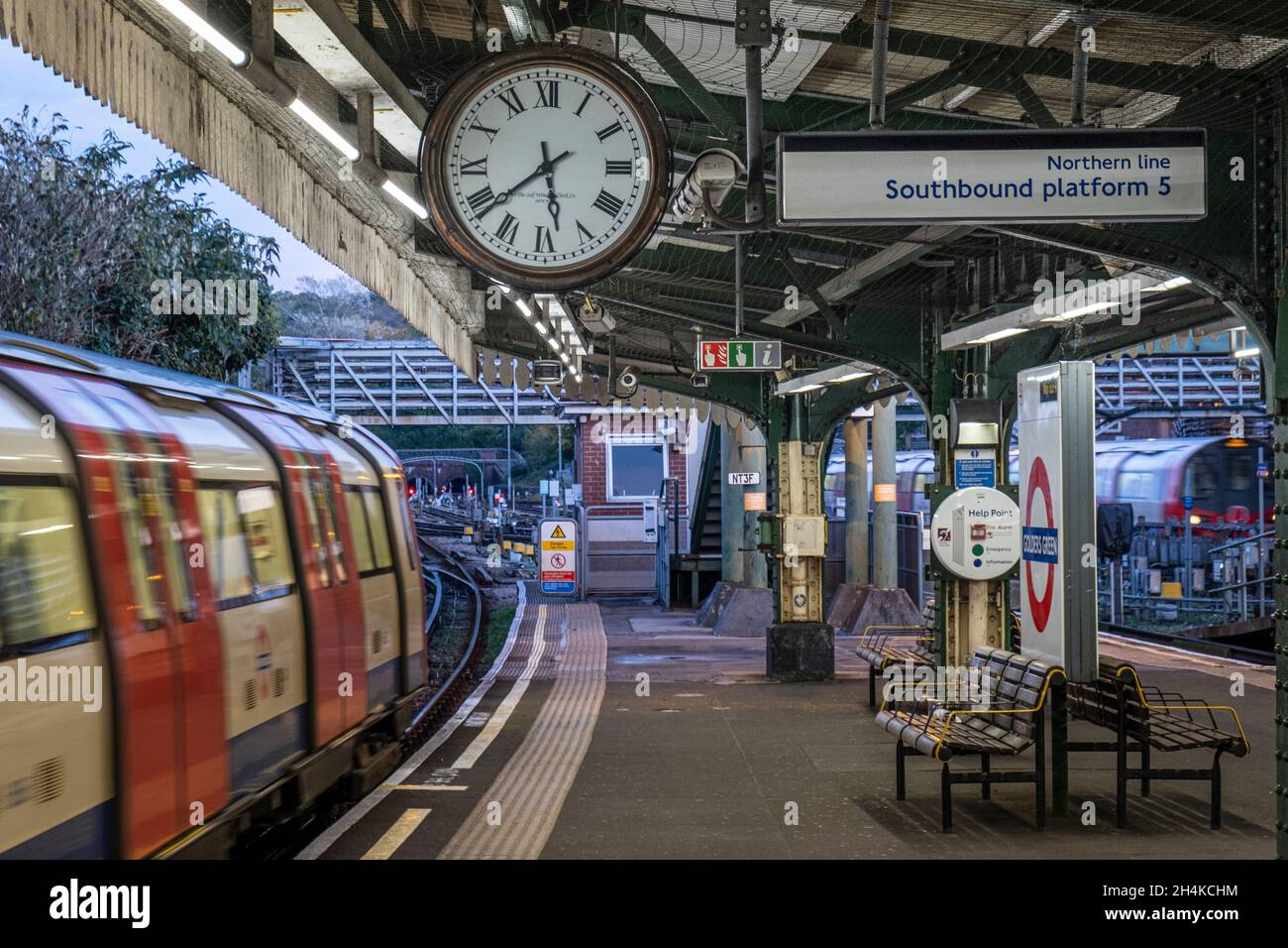 UK, Londra, stazione della metropolitana Golders Green, Northern Line, piattaforma in direzione sud. Piattaforma senza persone, luce del giorno, treno in arrivo alla stazione Foto Stock