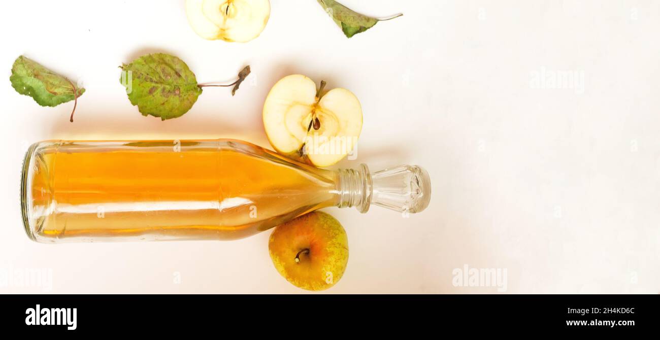 una bottiglia di aceto di sidro di mele e composizione di mele. Foto Stock