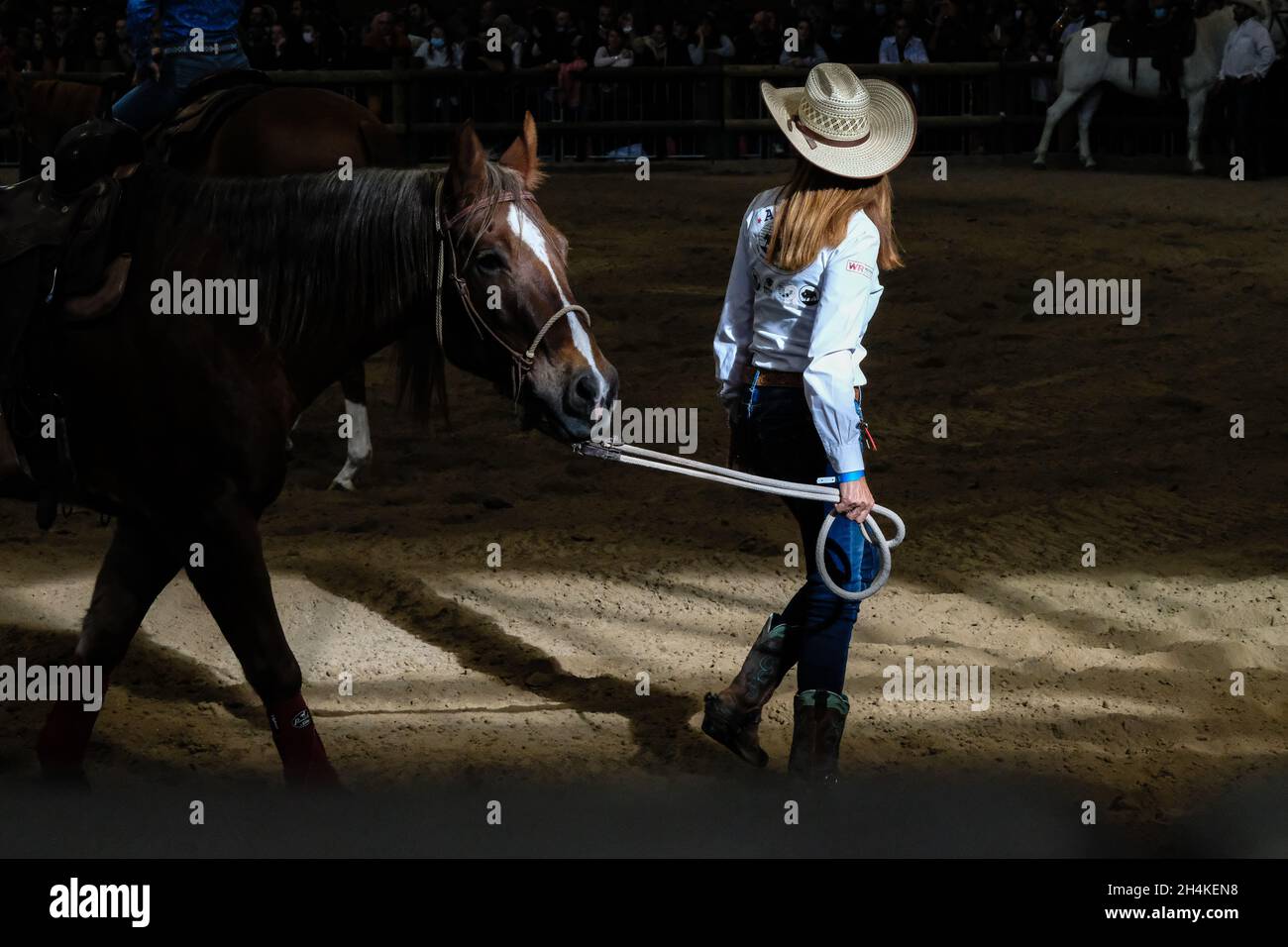 Lione (Francia), 30 ottobre 2021. Una donna da dietro vestita come cowboy con il suo cavallo prima di una manifestazione ranching. Foto Stock