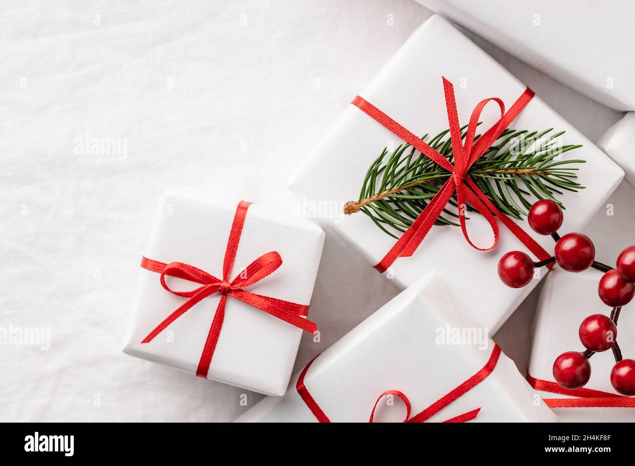 Primo piano delle scatole regalo di Natale su tovaglia bianca. Foto Stock