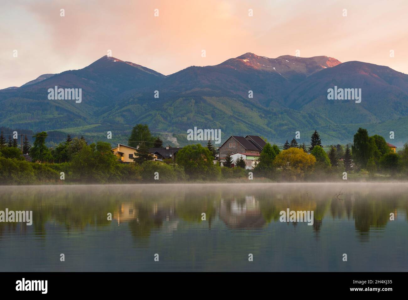 Vista del villaggio di Krpelany che si riflette nel canale del fiume Vah, Slovacchia. Foto Stock