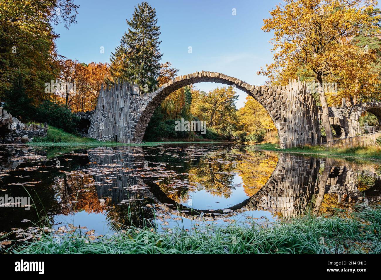 Ponte unico Rakotzbrucke, chiamato anche Devils Bridge, Sassonia, Germania. Costruito per creare cerchio quando si riflette in Waters.colorful caduta terra Foto Stock