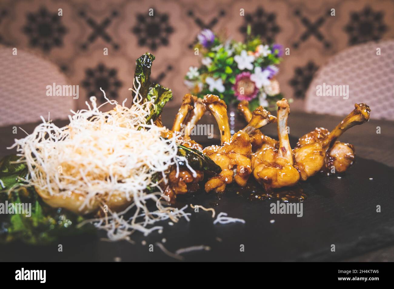 Ali di pollo su un piatto nero. Foto Stock