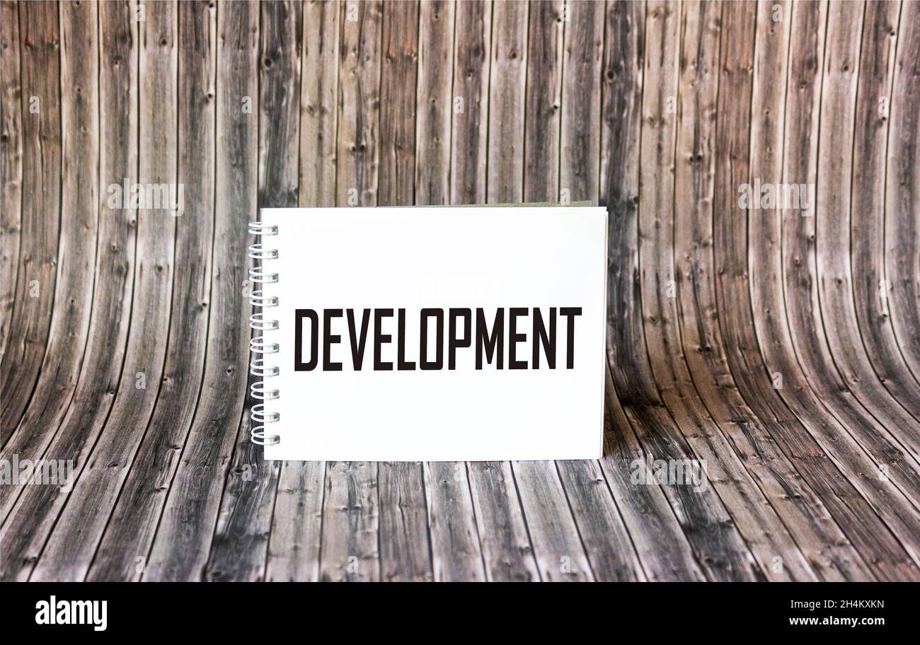 Concetto motivazionale. LO SVILUPPO della parola è scritto su un blocco note e su uno sfondo di legno. Foto Stock