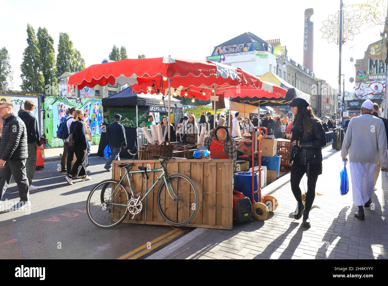 Bancarelle di cibo al vivace mercato Sunday Brick Lane al sole autunnale nella zona est di Londra, Regno Unito Foto Stock
