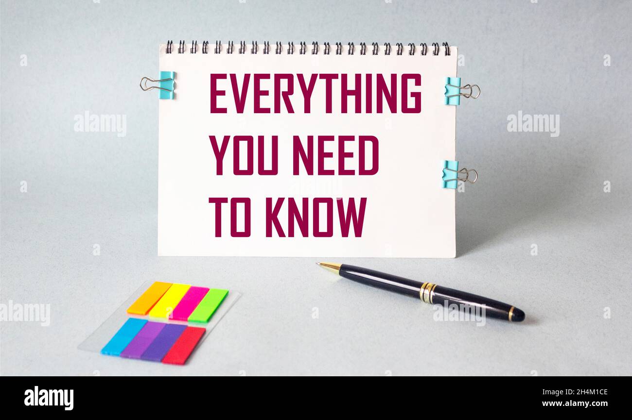 Tutto quello che devi sapere. La citazione motivazionale è scritta su un notebook su uno sfondo chiaro, accanto a adesivi e penne. Foto Stock