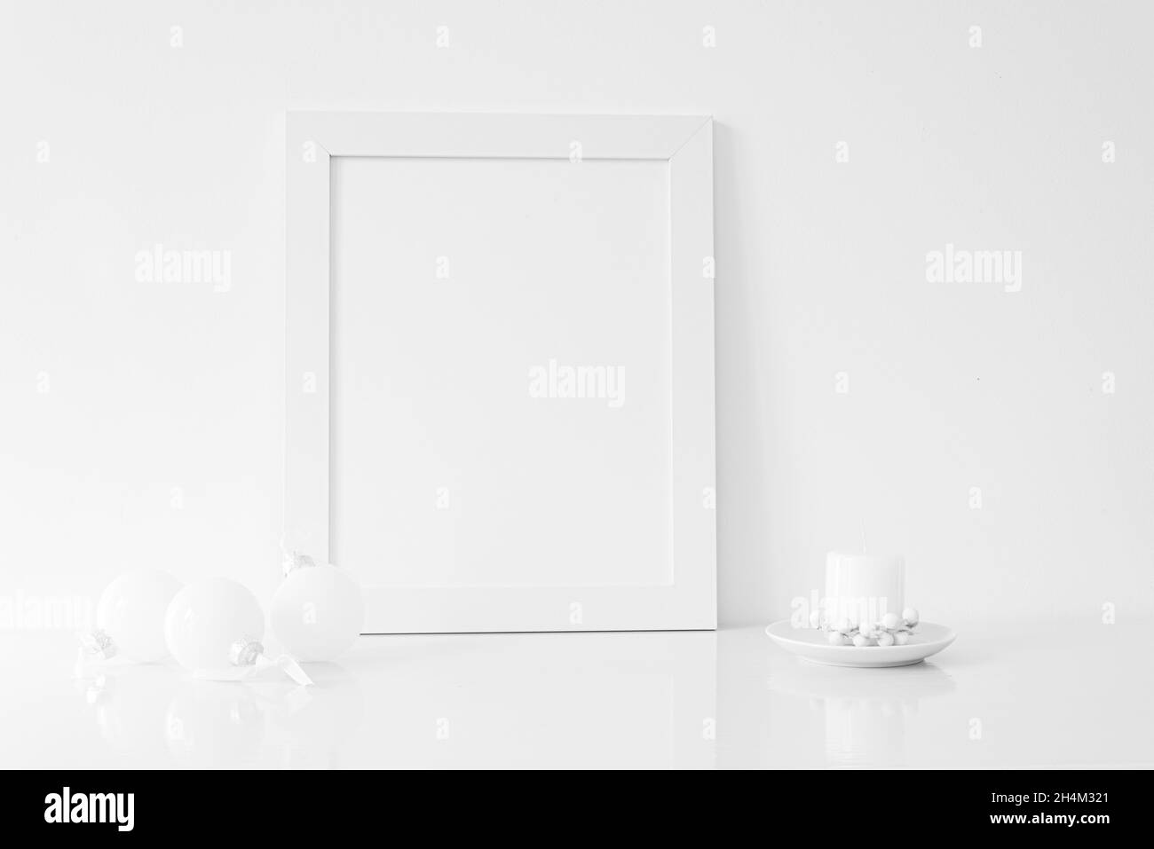 Bianco verticale mockup cornice con candela di Natale, e bianco Natale decorazioni. Natale, inverno, concetto festivo. Spazio di copia. Predom bianco Foto Stock