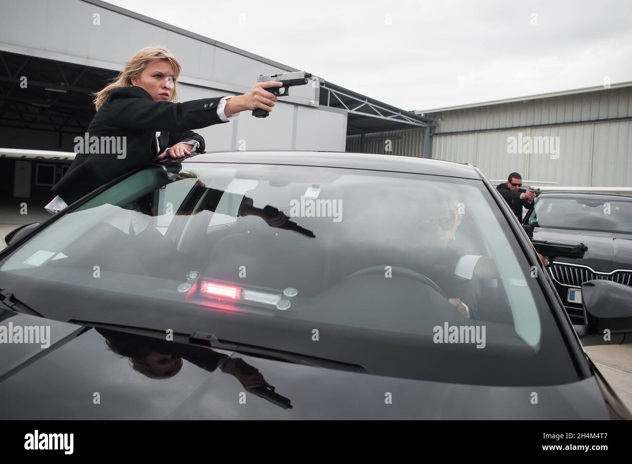 Il team armato professionale di guardie del corpo femminili e maschili protegge la persona della celebrità in limousine auto. Bodyguard e protezione personale VIP. Professate Foto Stock