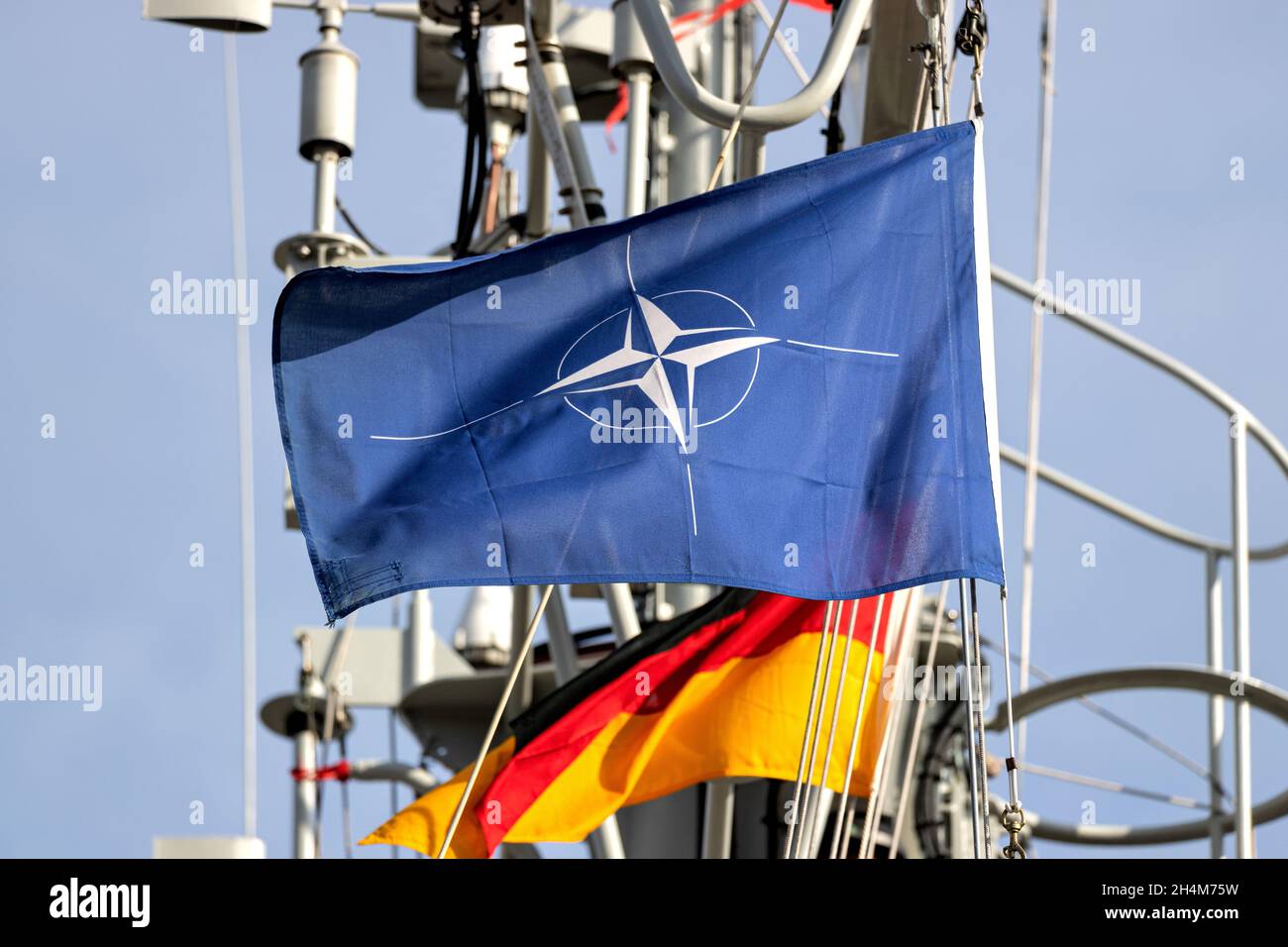 Bandiera dell'Organizzazione del Trattato del Nord Atlantico (NATO) che vola nel vento sull'albero di una nave da guerra Foto Stock