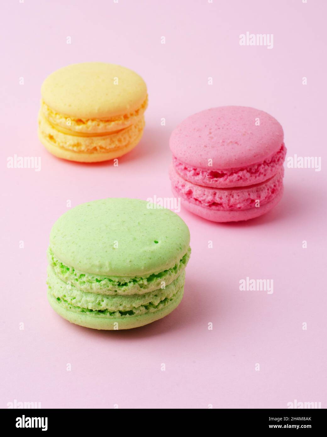 Torta macaron o macaroon biscotti di mandorle colorate, colori pastello su uno sfondo rosa Foto Stock