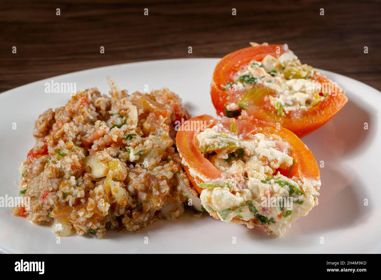 Insalata di tabbouleh con pomodoro ripieno. Cibo vegetariano. Piatto tradizionale medio-orientale o arabo. Vista dall'alto Foto Stock