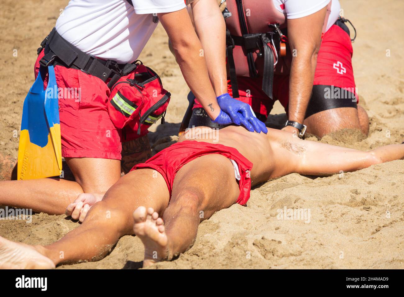 La Croce Rossa bagnini di salvataggio simulazione e CPR sulla spiaggia in Spagna. Foto Stock
