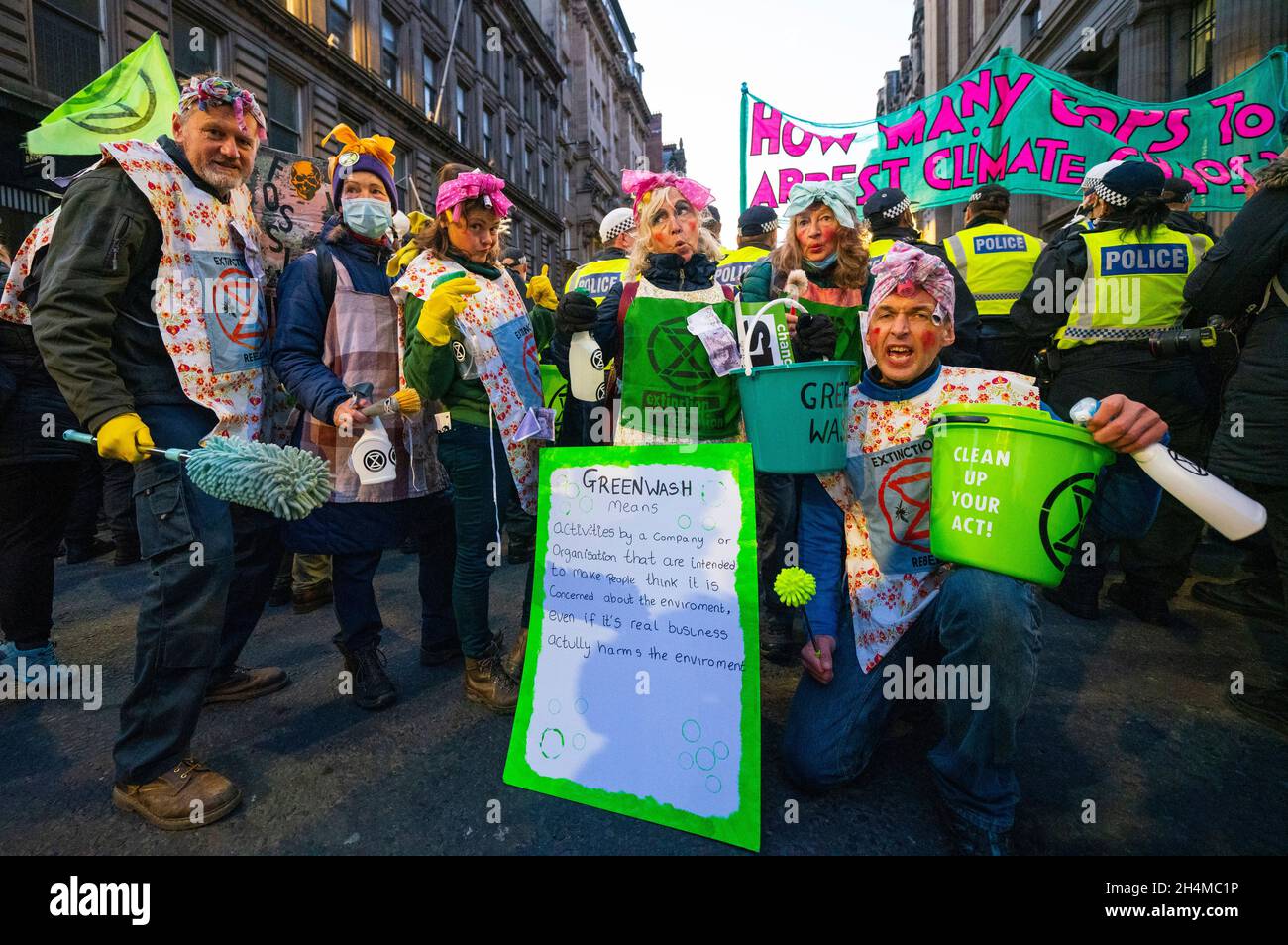 Glasgow, Scozia, Regno Unito. 3 novembre 2021. Il 4° giorno della Conferenza delle Nazioni Unite sul cambiamento climatico a Glasgow ha assistito a manifestazioni del gruppo di protesta della ribellione di estinzione nel centro di Glasgow. Dopo essere stati inseguiti dalla polizia hanno organizzato una seduta di protesta bloccando St Vincent Street. I manifestanti furono poi scortati e scortati attraverso la città e permisero di camminare oltre la sede della COP26 a Finnieston. PIC; i Dirty Scrubbers tentano di pulire la polizia , parte della loro protesta Greenwash. Iain Masterton/Alamy Live News. Foto Stock