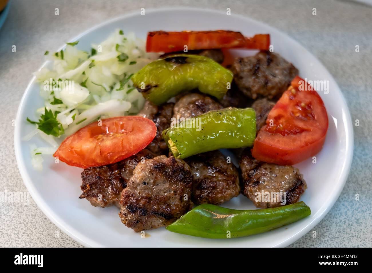 Izgara kofte, piatto tradizionale turco di polpette, grigliato con verdure sul piatto. Cucina turca foto Foto Stock