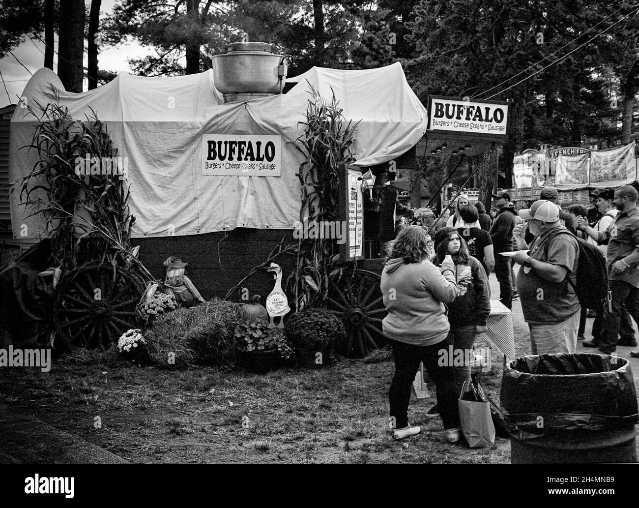 Il fornitore di cibo di nome Buffalo Burger è decorato come un carro coperto con una linea di clienti e una famiglia che mangia insieme mentre si trova al Deerfield Foto Stock