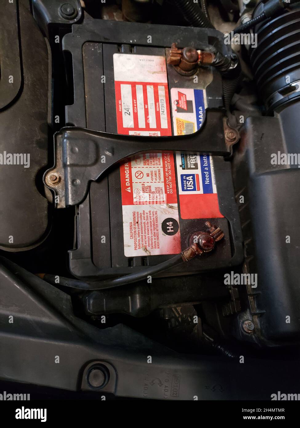 Vecchia batteria per auto con corrosione intorno a un terminale Foto Stock