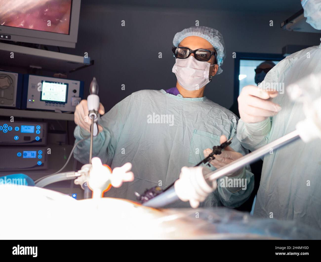 Un chirurgo femminile che indossa occhiali 3D opera un paziente con manipolatori laparoscopici. Chirurgia minimamente invasiva. Messa a fuoco selettiva. Foto Stock