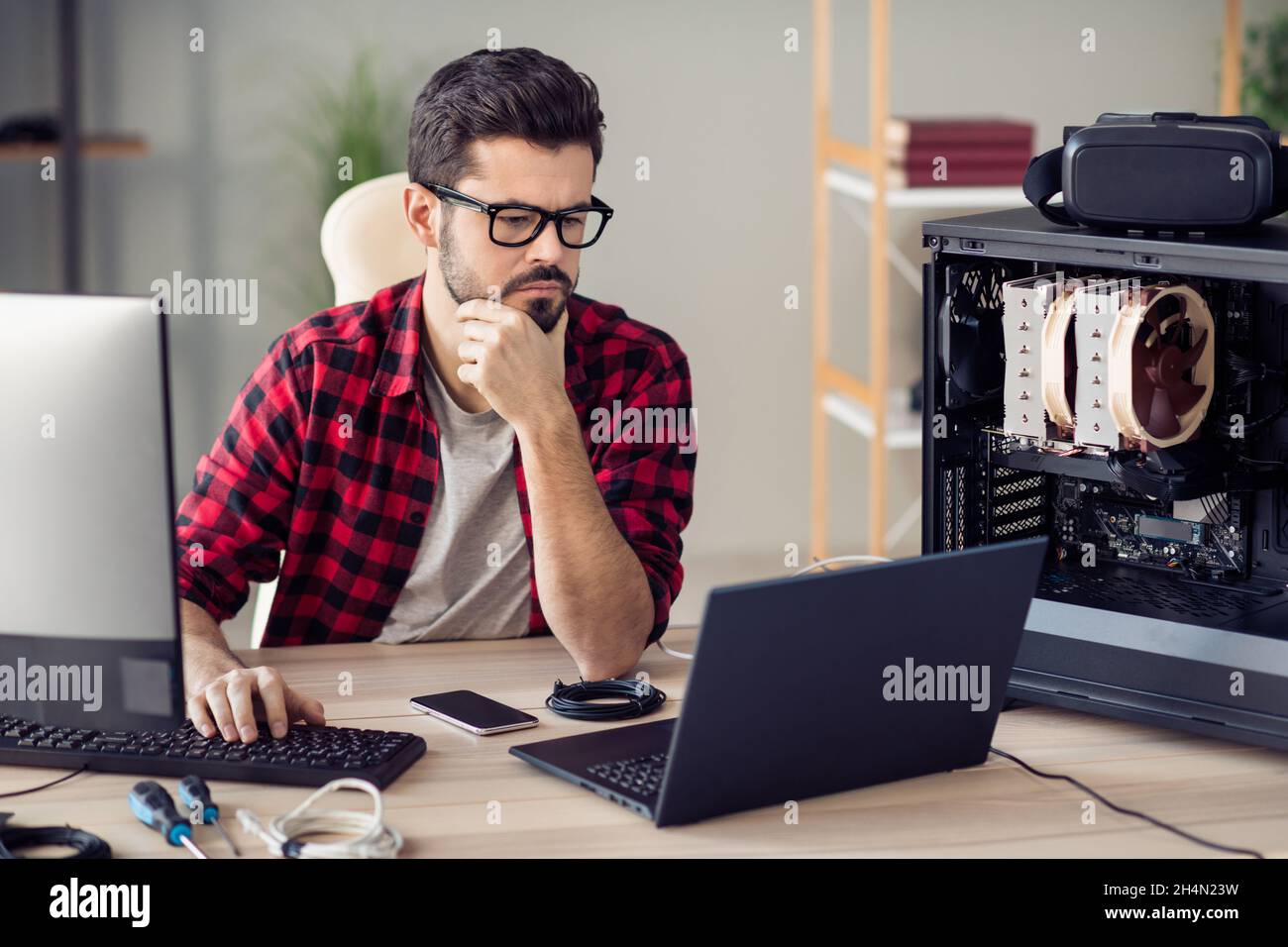Ritratto di attraente qualificato ragazzo senior dev Ops manager programmazione debug presso la postazione di lavoro in ufficio al chiuso Foto Stock