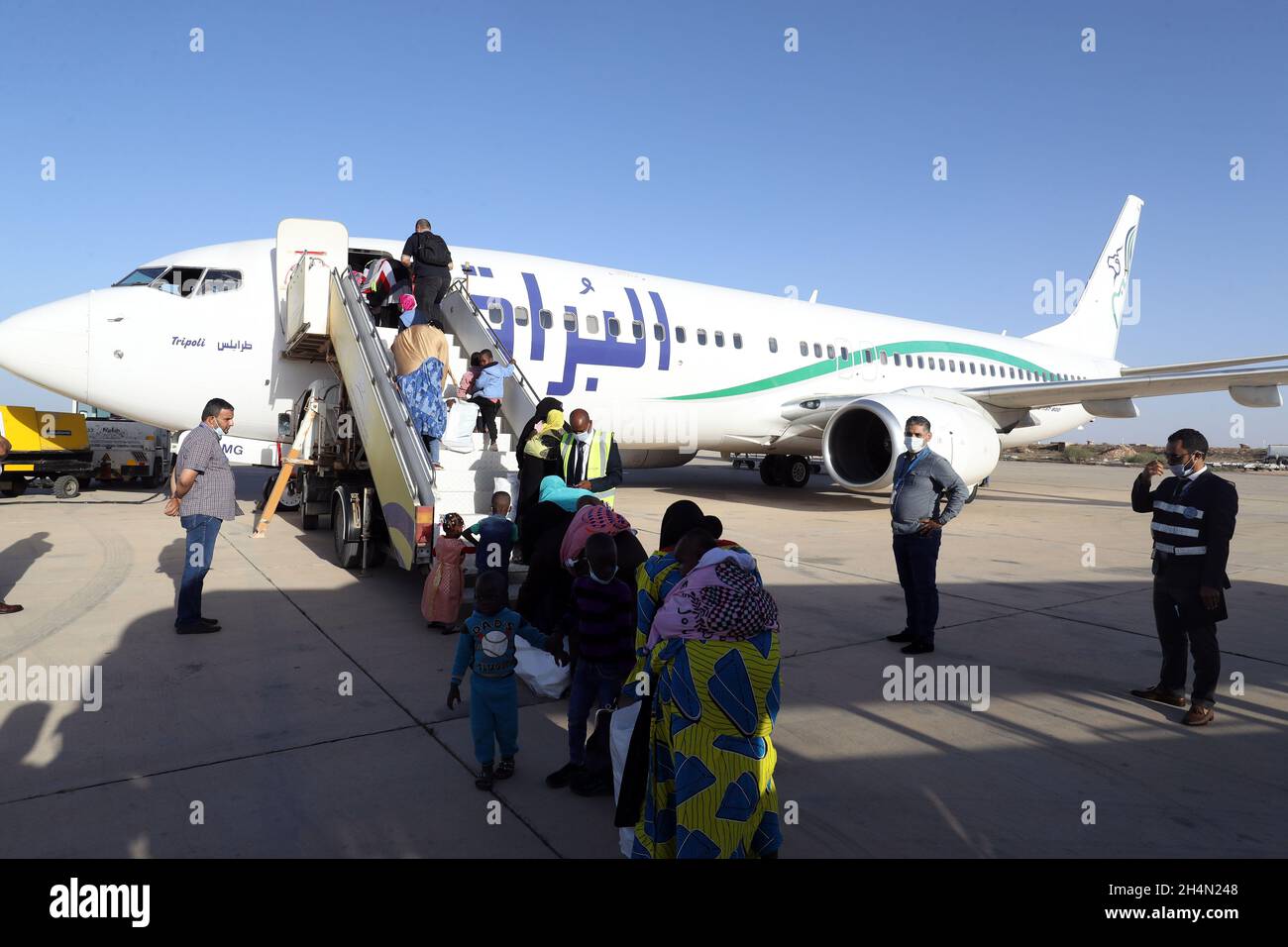 Misurata, Libia. 3 novembre 2021. Gli immigrati clandestini si accodano a bordo di un aereo all'Aeroporto Internazionale di Misurata, in Libia, il 3 novembre 2021. Mercoledì un gruppo di 91 immigrati clandestini, per lo più bambini, sono stati volontariamente rimpatriati dalla Libia nel loro paese d'origine Niger. Credit: Amza Turkia/Xinhua/Alamy Live News Foto Stock