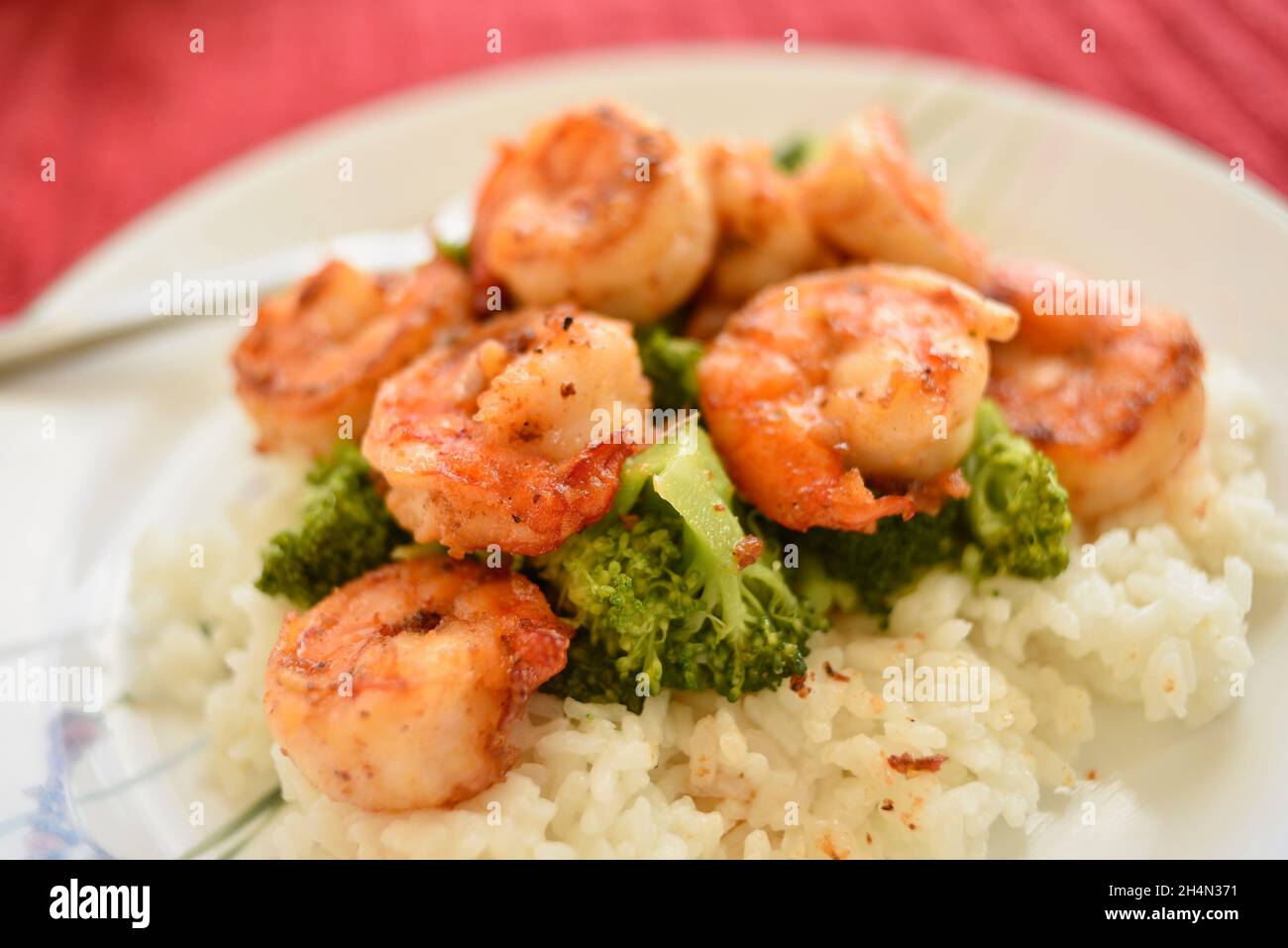 Il famoso gambero all'aglio North Shore servito su broccoli e riso su un piatto bianco, Oahu, Hawaii, USA Foto Stock