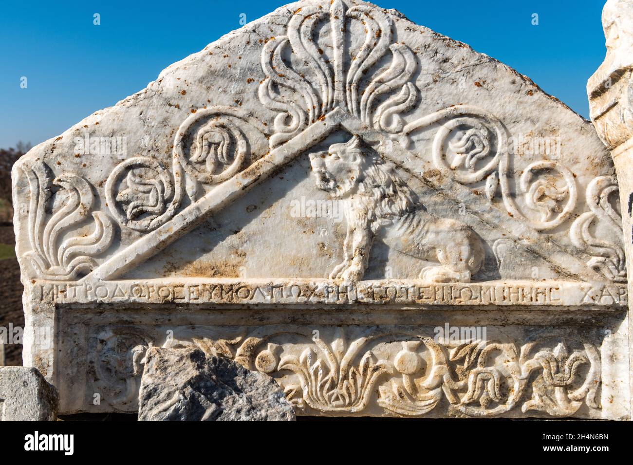Cavdarhisar, Kutahya, Turchia – 17 novembre 2020. Frammento triangolare di una stele marmorea raffigurante una figura leone, motivi palmette e un INS greco Foto Stock